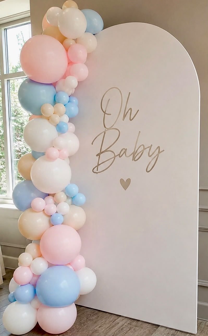 Cream arch backdrop with a pastel pink, blue and cream balloon garland