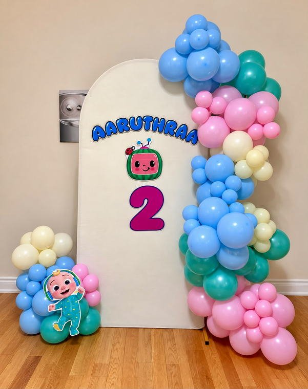 CoComelon themed second birthday backdrop with a custom name and character cutouts